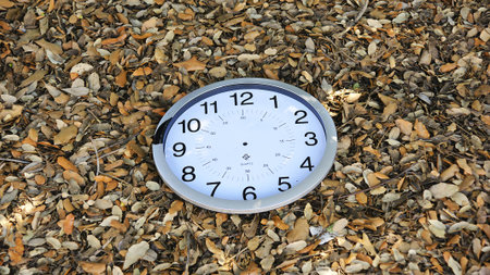 Broken clock on dead leaves for backgrounds and textures