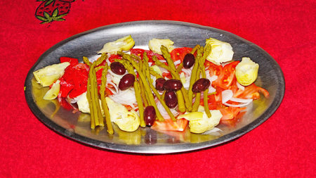 Tray of tomato salad, asparagus and olives on the tableの写真素材
