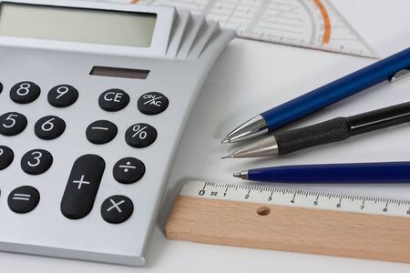 Close-up of a calculator with pens and a rulerの写真素材