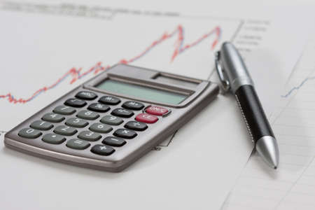 Close-up of a calculator and a pen on a chartの写真素材