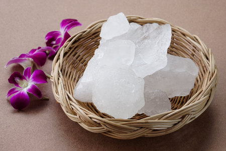 Crystal clear alum stones or Potassium alum on basket, decorated with flowers. Useful for beauty and spa treatment. Use to treat body odor under the armpits as deodorantの写真素材