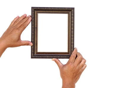 Hands hold photo frame, isolated on white background. Copy space for adding text or photos. Concept, Proud, memories and nostalgia. Exhibition, art gallery. Photography.の写真素材