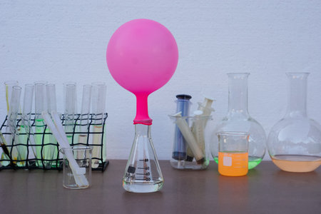 Science experiment , pink inflated balloon  on top of transparent test bottle. The experiment about...