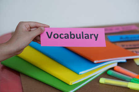 Closeup student's hand hold English vocabulary word card. Concept, education, learning, studying language. Education. Reading and memorizing strategy of learning process for kid.の写真素材