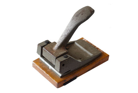 Old vintage iron paper hole puncher isolated on white background. Concept, office tool, equipment to  make hole of paper document before arranging or keeping into binders file.の写真素材