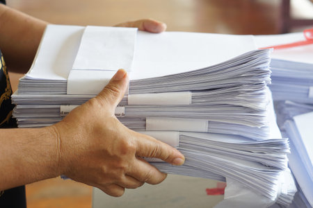 Closeup hands hold stack of used paper to recycle or combine to use next time to print out both...
