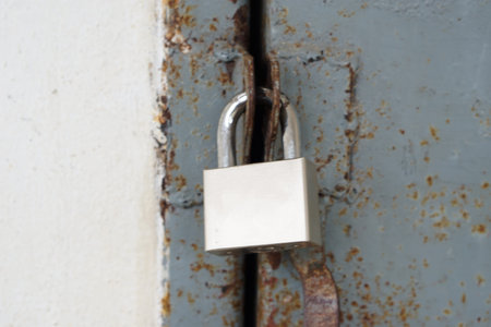 Old padlock on a rusty metal door. Selective focus.