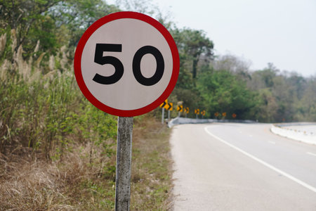 Warning road sign with number 50 on red circle to warn limit speed ,do not drive more than 50 km. per hour on the rural road in Thailand. Concept , traffic sign speed limit 50の写真素材