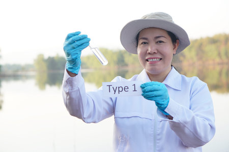 Asian woman ecologist hold tube of sample water and tag with word Type 4 for inspect and research...