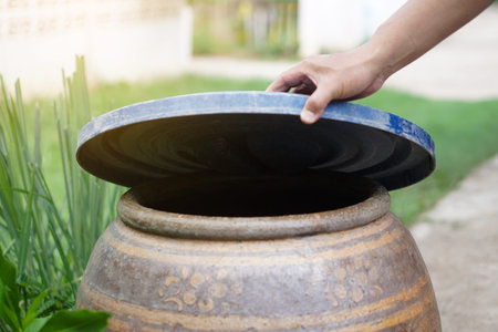 Closeup hand hold lid to cover water jar to protect from mosquito to breed inside or other  insects...