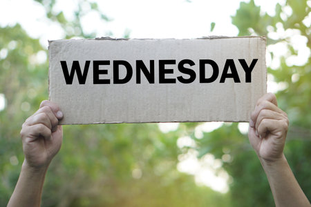 Hands hold word card for teaching with word WEDNESDAY. Concept, language teaching vocabulary about day in a week.  Education. Word spelling. Memory vocabulary game  teaching aids.の写真素材