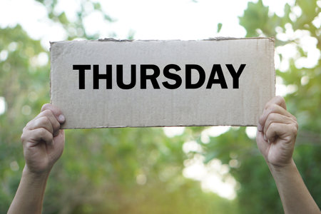 Hands hold word card for teaching with word THURSDAY. Concept, language teaching vocabulary about day in a week.  Education. Word spelling. Memory vocabulary game  teaching aids.の写真素材