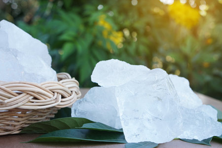 Crystal clear alum stones or Potassium alum on basket, decorated with flowers. Useful for beauty and spa treatment. Use to treat body odor under the armpits as deodorantの写真素材