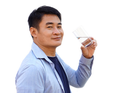 Handsome Asian man holds transparent glass of water to drink, isolated on white background. Concept, drinking water for health at least 8 glasses a day. Health care.  Healthy lifeの写真素材