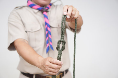 Tying rope knot pattern, demonstrated by scout teacher trainer. Concept, useful tying knot for many purposes in daily life. Tying knot rope teaching aid. Life skills with rope.の写真素材