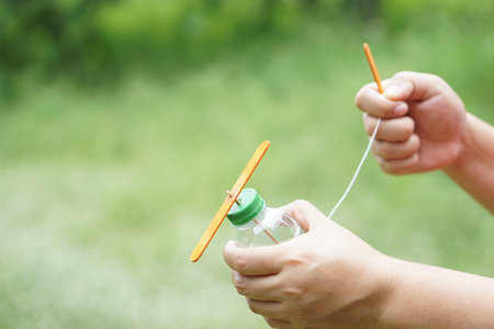 Close up hands hold DIY toy made from plastic bottle, rope and ice cream stick. Concept, Recycle...
