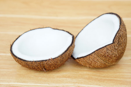 Half cut coconut fruits to show white meat inside on brown background. Concept , Food ingredient for making coconut milk  and cooking Thai dessert from nature.の写真素材