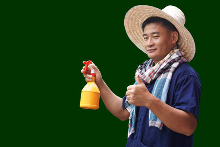 Asian man farmer wears hat, blue shirt, Thai loincloth scarf and holds spray bottle, thumbs up,...