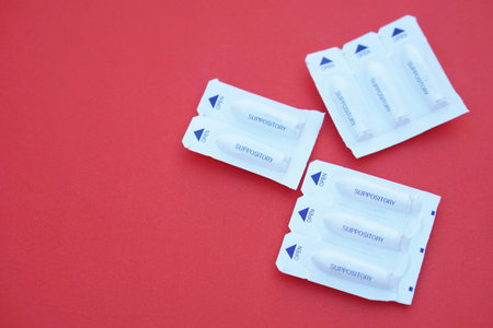 Packages of suppository medicine for pain in the rectum, hemorrhoids, and inflammation . Red background. Concept, Health care, medical treatment. Use under prescription.の写真素材