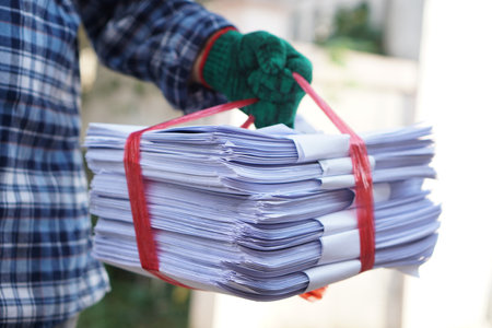 Close up man hold pile of used paper, tied with rope. Concept, sorting garbage for recycle next steps. Eco friendly activity. Waste paper management. Reduce reuse, recycle paper.の写真素材