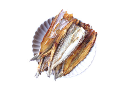Dried salted fish in plate, isolated on white background. Concept food  product from food preservation process, can be cooked in various menu. Top view.の写真素材