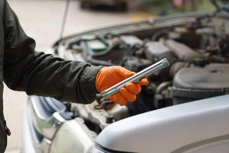 Auto mechanic using wrench to fix a car. Close-up.