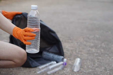 Closeup hand wear gloves, hold plastic bottle. Concept, garbage management, reused, recycled plastic...