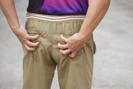 Close up man hands massage or scratch bottom. Concept, pain, hurt, ache from daily life activity or...