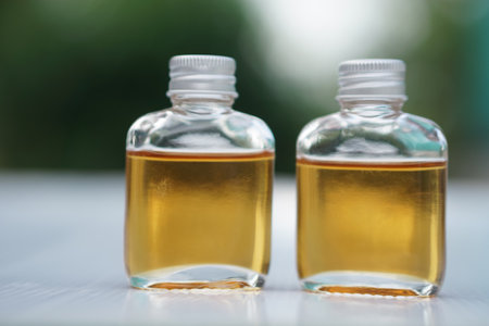 Transparent glass bottles of homemade herbal massage oil. Concept, Thai local wisdom to use fragrant medicinal herbs to make  massage oil for aromatherapy and relaxation.の写真素材