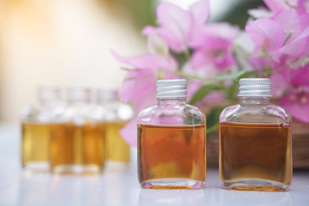Transparent glass bottles of homemade herbal massage oil. Concept, Thai local wisdom to use fragrant medicinal herbs to make  massage oil for aromatherapy and relaxation.の写真素材