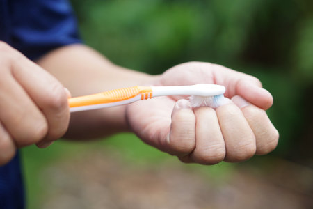 Close up  hand hold old toothbrush to clean nails. Concept. better than throw away,reuse old toothbrush to be equipment to clean dirty on finger nails. Health care and eco friendlyの写真素材