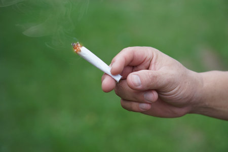 Close up hand holds homemade cigarette for smoking. Concept, smoking is bad for health. Private favorite for relaxation but can cause health problems and bad smell.の写真素材