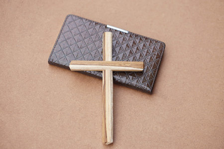 Wooden crucifix on book. Brown background. Concept, Christian worship. Faith, forgiveness, belief,...