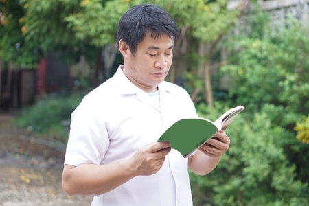 Asian man is reading book. Concept, Relax time, pastime, hobby. Give time for yourself to read books , magazine, novels. Reading in daily life. Education, knowledge or  pleasure.の写真素材