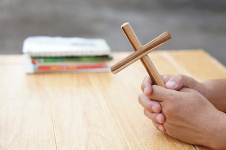 Close up Christian man holding a wooden crucifix to pray. Concept, Christian worship. Faith,...