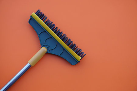 Brush for cleaning floor on orange background. Concept, tool for cleaning. use for scrub dirty on bathroom floor.の写真素材