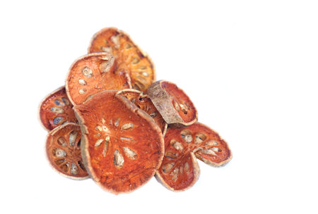 Dried sliced bael fruits isolated on white background. Concept, Herbal drink ingredient with...
