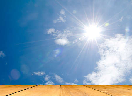 wood floor with sun star and blue sky background.の写真素材