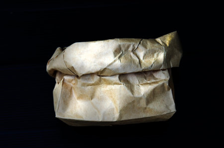 Brown paper bag on a black background.