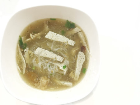 Chicken soup with noodles and vegetables in white bowlの写真素材