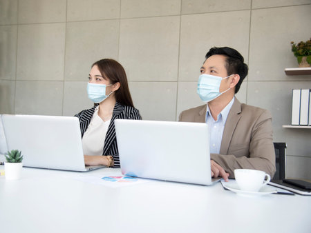 Asian office workers wear face masks at corporate meetings to prevent the , or , ideas for a new normal lifestyle in the workplace. Awareness of wearing masksの写真素材