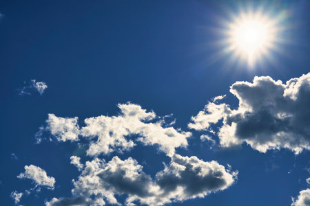 Sun rays and white cloudsの写真素材
