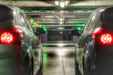Two cars on the underground parking with stop signals.