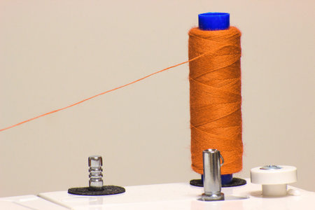 Red thread tucked into the sewing machine. New year is coming. Sewing for new year and Christmas