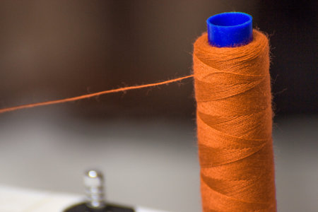 Red thread tucked into the sewing machine. New year is coming. Sewing for new year and Christmasの写真素材