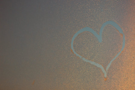 Heart image on the freeze window. Picture on the Iced water drops. Winter painting
