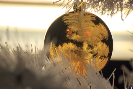 Gold ball on a white Christmas tree, decorations for new year and Christmas. Cozy home, preparing for fun. Background for greeting cardsの写真素材