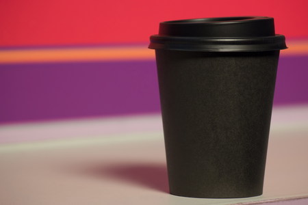 black paper Cup with plastic lid. coffee or takeaway on violet and pink background. brutal glassの写真素材