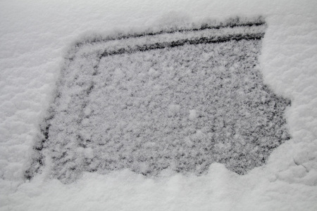 the car under snow cap. flakes of snow on the mirror and the whole car. winter has comeの写真素材
