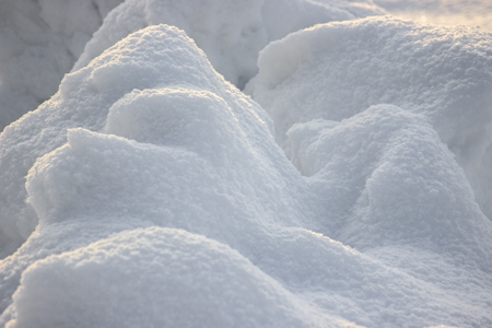 Snow snowbank on Sunny day. Fluffy snow shimmers in the sun, abstract natural figuresの写真素材